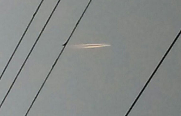 New York witness photographs hovering cigar UFO